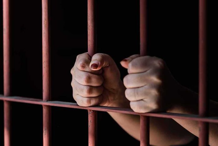 Hands gripping prison bars