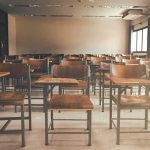 Empty classroom with rows of wooden desks and chairs