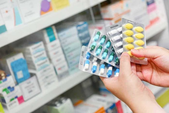 shutterstock_1023851305 Hands holding blister packs of assorted pills in a pharmacy