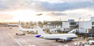 Bloody Cockpit Brawl at 35,000 Feet Airplanes at airport gates during sunset with ground vehicles and jet bridges