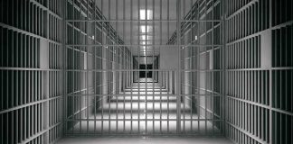 empty prison corridor with barred cells