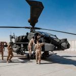 War Zone Apache Down — What Hit It? Soldiers inspect a military attack helicopter on a tarmac