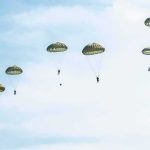 Two-Mile Freefall Miracle – While Unconscious! Parachutists descend under round canopies in a clear sky