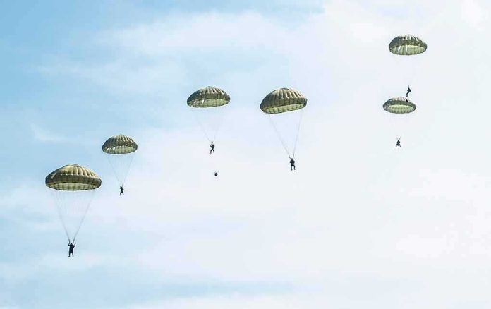 shutterstock_1263585256 Parachutists descend under round canopies in a clear sky