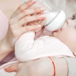 Judge Slams Surrogacy Machine Baby drinking from a bottle while being held