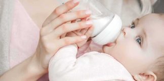 Judge Slams Surrogacy Machine Baby drinking from a bottle while being held