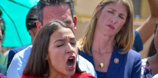 woman in red speaking passionately at microphones
