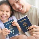 Smiling child and adult holding passports