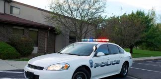 Unarmed Student Killed—Officer Charged Police car with flashing lights parked outside a building