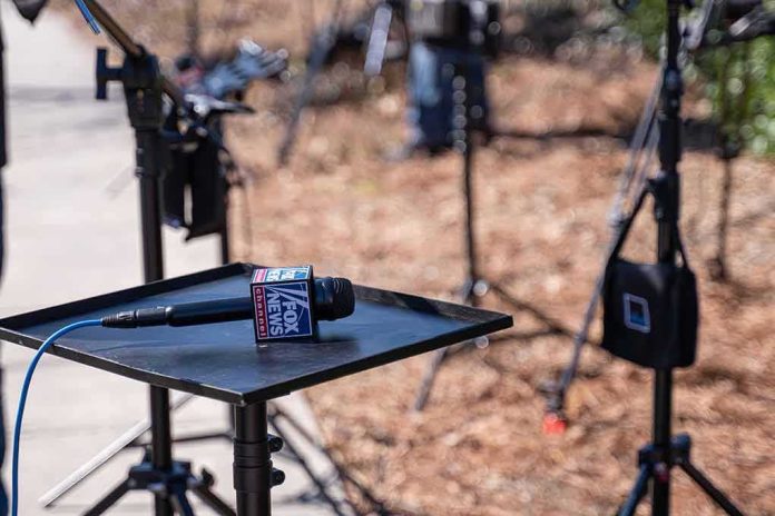 shutterstock_1719688624 Microphone on a small stand-up table at an outdoor media setup
