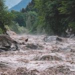 Sudden Ice Avalanche Erases Villages Flooded river gorge with fast muddy water and rocks