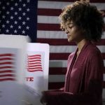 New Hampshire Upset Could Flip Congress Voter at a polling booth with an American flag backdrop