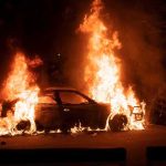 Burning car engulfed in flames at night