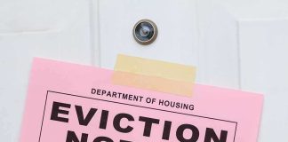 Eviction notice taped to a white door