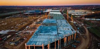 Trump’s $15B Steel Gamble Shocks Industry aerial view of large industrial building under construction at sunset