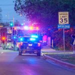 Emergency vehicles with flashing lights on a city street at night