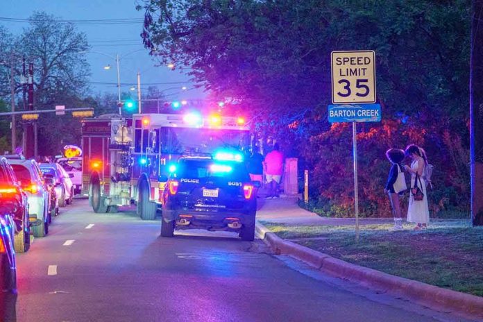 Emergency vehicles with flashing lights on a city street at night