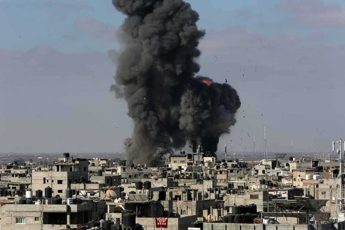 shutterstock_1973247644 Thick black smoke rises from an explosion over a dense urban area