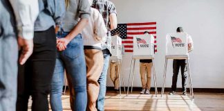 Voters stand in line and cast ballots at voting booths