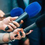 Primetime Broadside Slams Democrats’ “Radical” Playbook Reporters holding colorful microphones