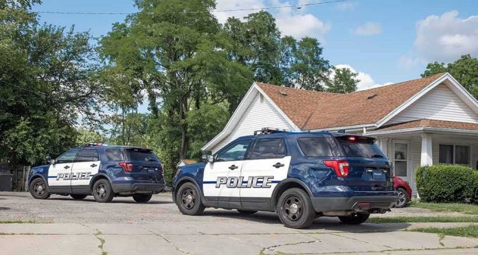 shutterstock_2195086633 Two police SUVs parked near a suburban house