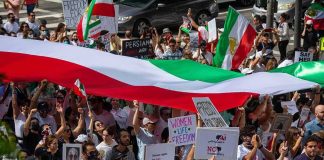 Currency Freefall Triggers Unrest Fears Crowd of protesters holding signs and a large tricolor flag