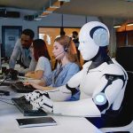 Paris Showdown: Vance Dares AI Skeptics Robot and office workers at computers in a modern workspace