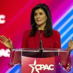 Nikki Haley speaks at a podium with a colorful backdrop