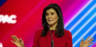 Nikki Haley speaks at a podium with a colorful backdrop