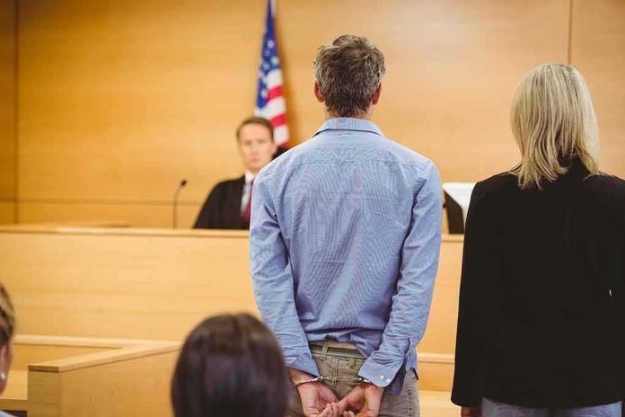 shutterstock_243763714-2 Defendant in handcuffs standing before a judge in a courtroom