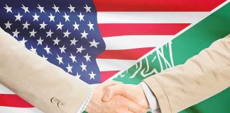 No U.S. Bombs — What’s The Catch? Handshake between two people over U.S. and Saudi flags