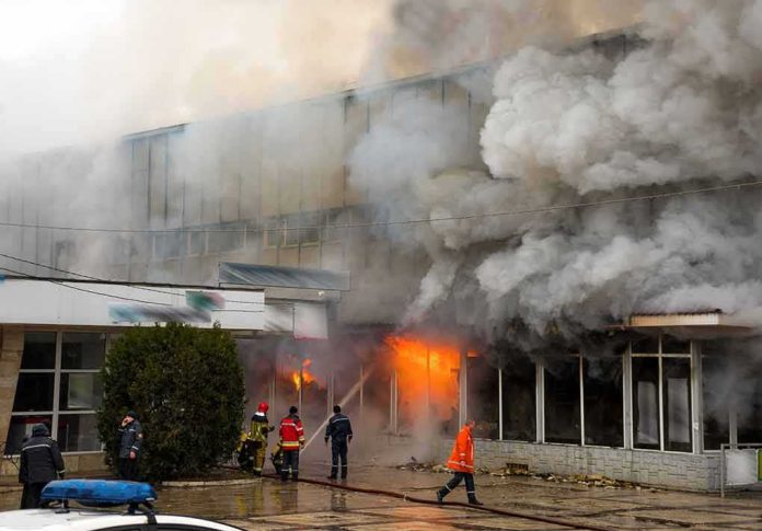 shutterstock_404947000 firefighters respond to large building fire with heavy smoke
