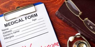 medical form on clipboard with stethoscope and glasses