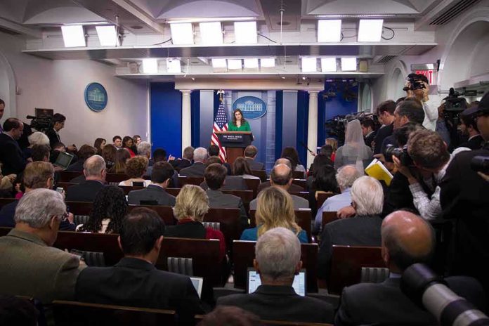 shutterstock_744405130-1 Press secretary at podium addressing reporters in briefing room