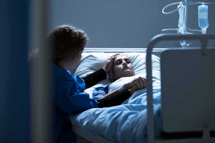 shutterstock_1030133815 Patient in hospital bed with visitor holding their hand