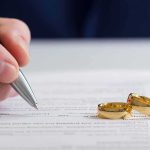 11-Year-Old Bride Case Sparks Uproar Hand signing a document beside two gold wedding rings