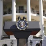 Five-Day Firing Shocks White House Presidential podium with seal in front of white-columned building