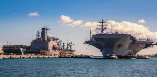 Carrier Marathon Ends – Alarming Confession On Deck Aircraft carrier and support ships docked at a naval harbor