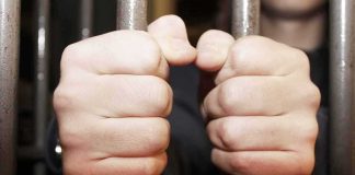 Spy Chief ARREST Shocks Europe hands gripping prison bars