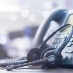Endless Loops, No Humans – What Changed? Headset resting on an office desk phone