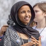 Ilhan Omar wearing a black headscarf at an outdoor event