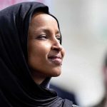 Rep. Ilhan Omar’s Clip Ignites Explosive Family Mystery Ilhan Omar in profile wearing a black headscarf outdoors