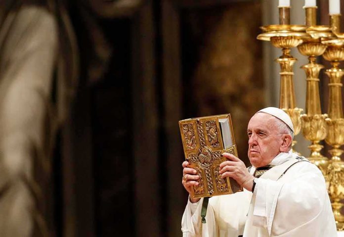 Catholic priest holds ornate book during ceremony