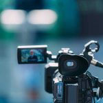 Video camera filming a speaker at a podium