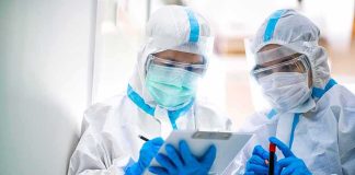 Border Alert Ignored? Ebola Slips Into Kenya Two healthcare workers in full PPE reviewing a clipboard