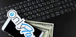 Teacher’s Adult Site Gets Her Fired Smartphone with OnlyFans sticker and cash on a laptop keyboard