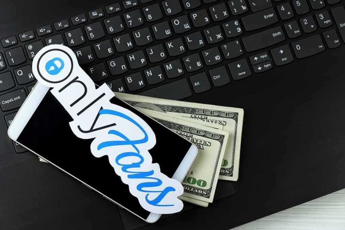 shutterstock_1941289663-1 Smartphone with OnlyFans sticker and cash on a laptop keyboard