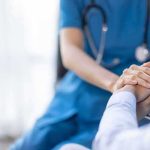 Nurse comforting a patient by holding hands