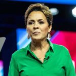Drunk Confession Ignites Indiana Firestorm Woman speaking on stage in a green shirt