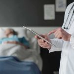 Rushed Euthanasia After Suicide Hold? Doctor using tablet beside hospital patient